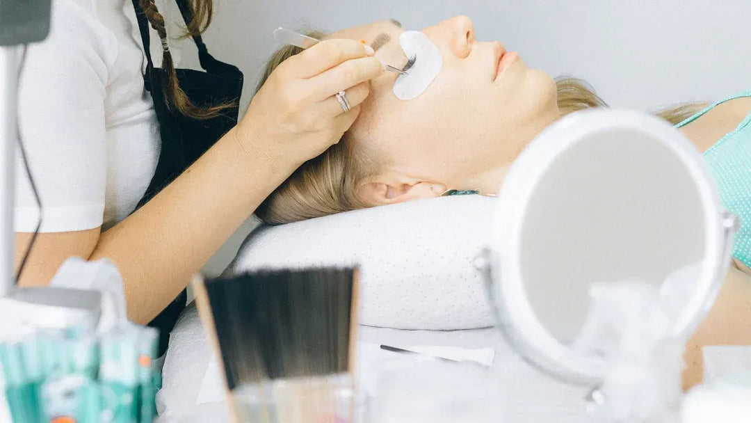 A woman receiving eyelash extensions at a beauty salon.